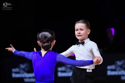 Dancesport competitor: Male dancer: white long-sleeved shirt, black trousers, and a black bow tie
