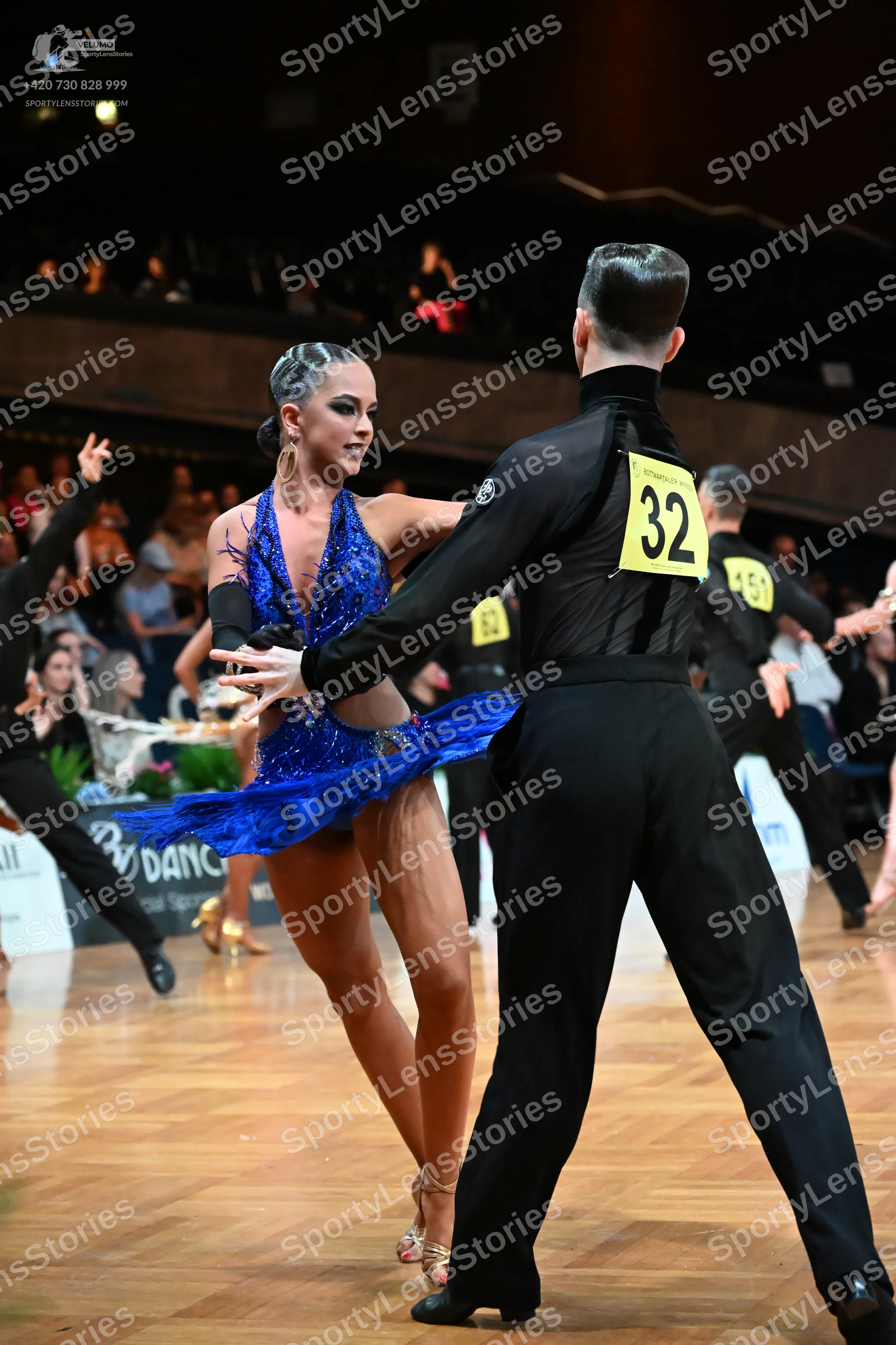 Dancesport competitor #32, #59: Male dancer (foreground): black long-sleeved shirt and black trousers