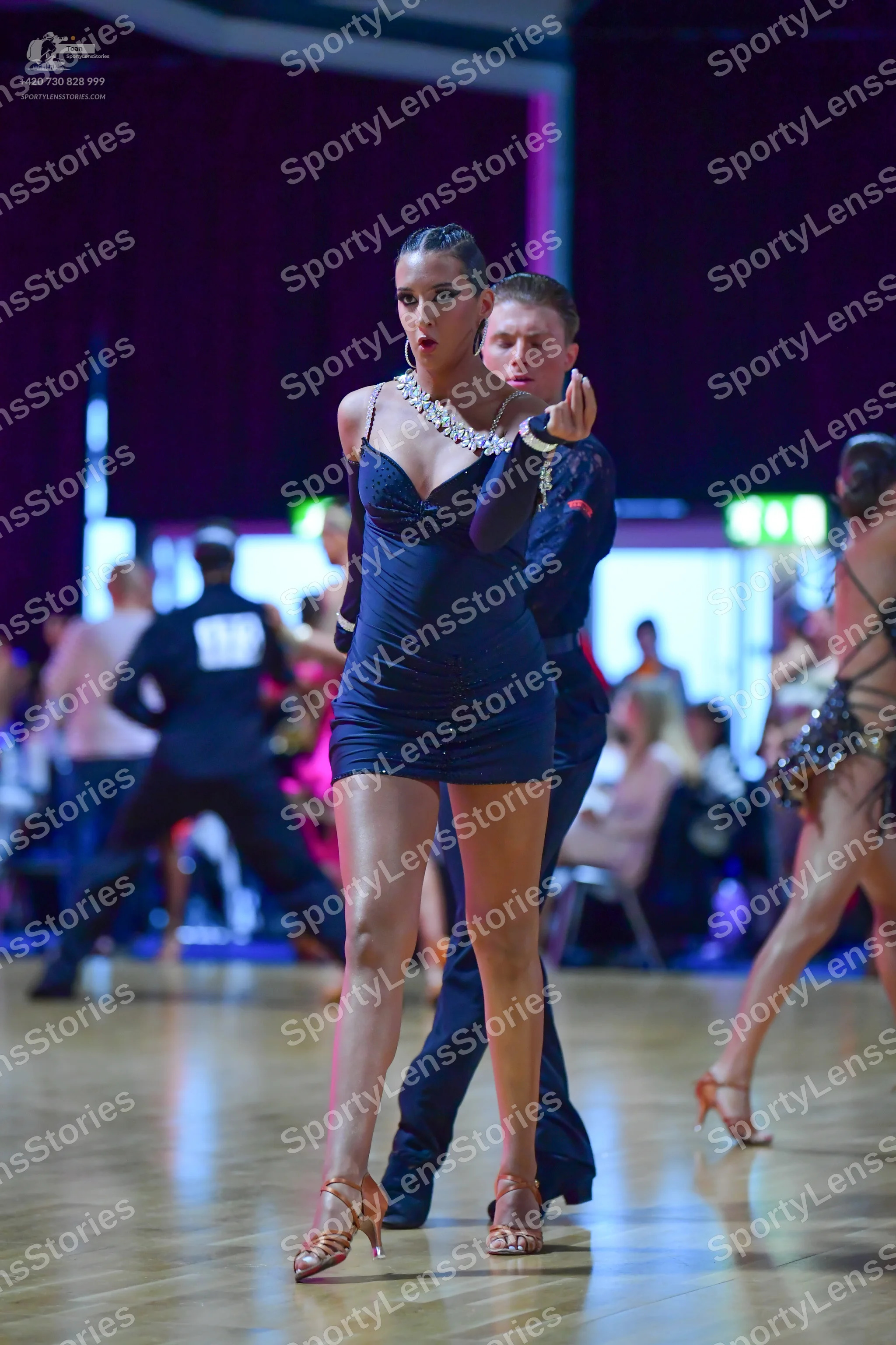 Dancesport competitor: Main female dancer: black short latin dress with thin straps and heavy silver rh