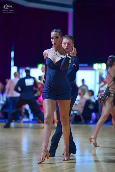 Dancesport competitor: Main female dancer: black short latin dress with thin straps and heavy silver rh