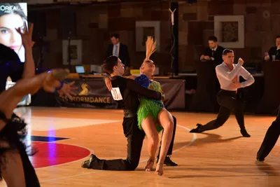 Dancesport competitor: Central male dancer: black long-sleeved shirt and black trousers