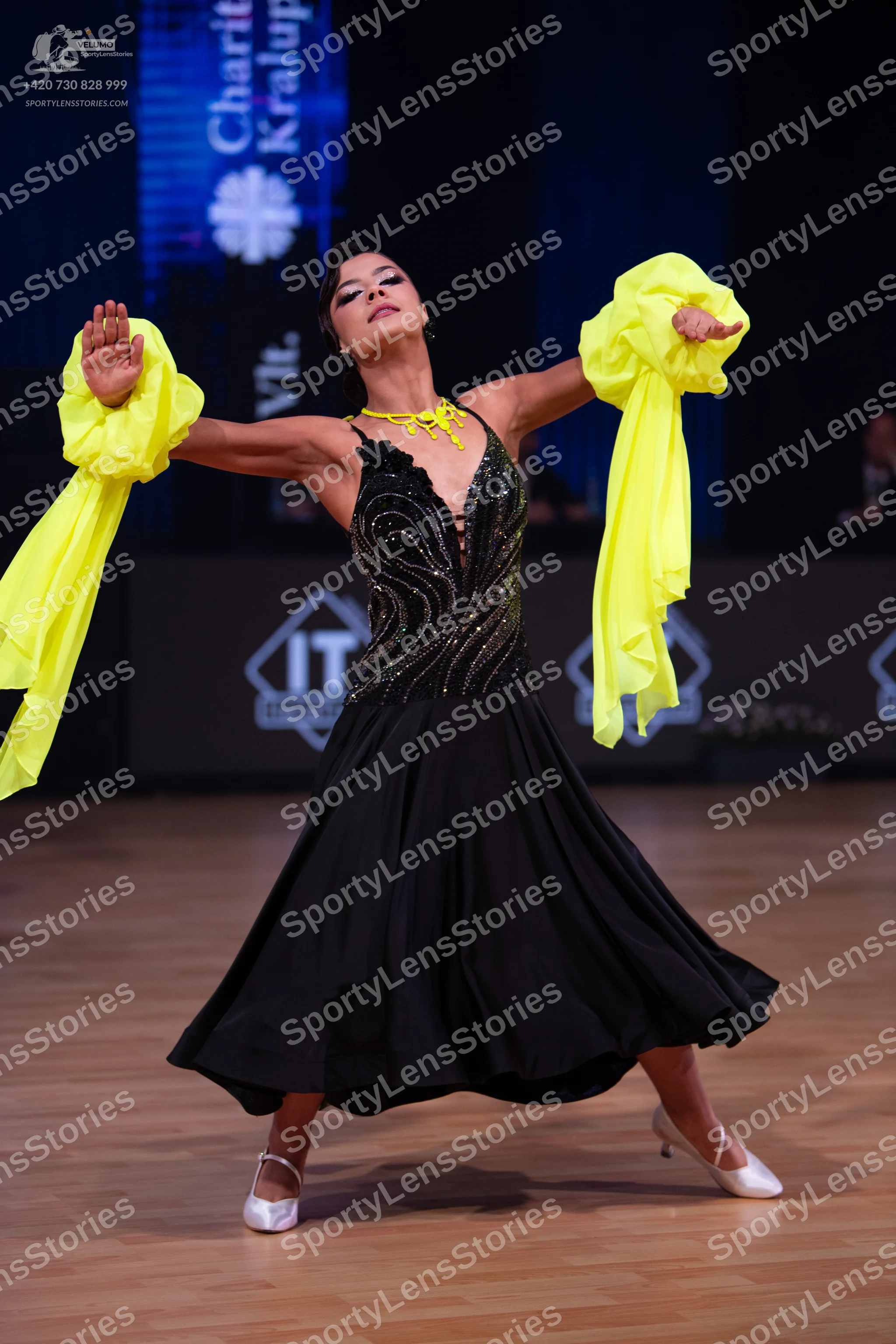 Dancesport competitor: Female dancer: black ballroom dress with a sequined bodice, a large flowing blac