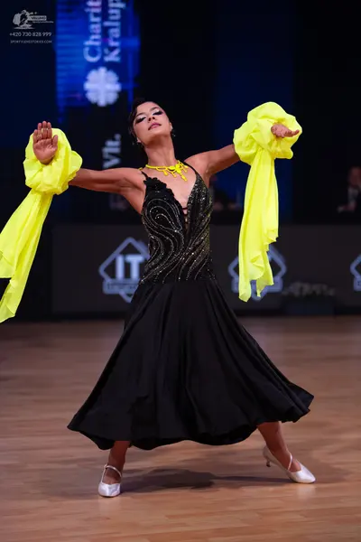 Dancesport competitor: Female dancer: black ballroom dress with a sequined bodice, a large flowing blac
