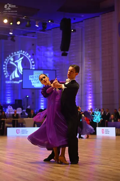 Dancesport competitor: Female dancer: long, flowing purple ballroom gown with a full skirt