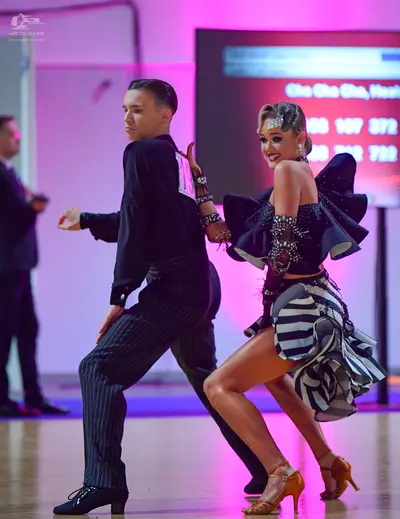 Dancesport competitor: Male dancer: black long-sleeved shirt and black pinstriped trousers
