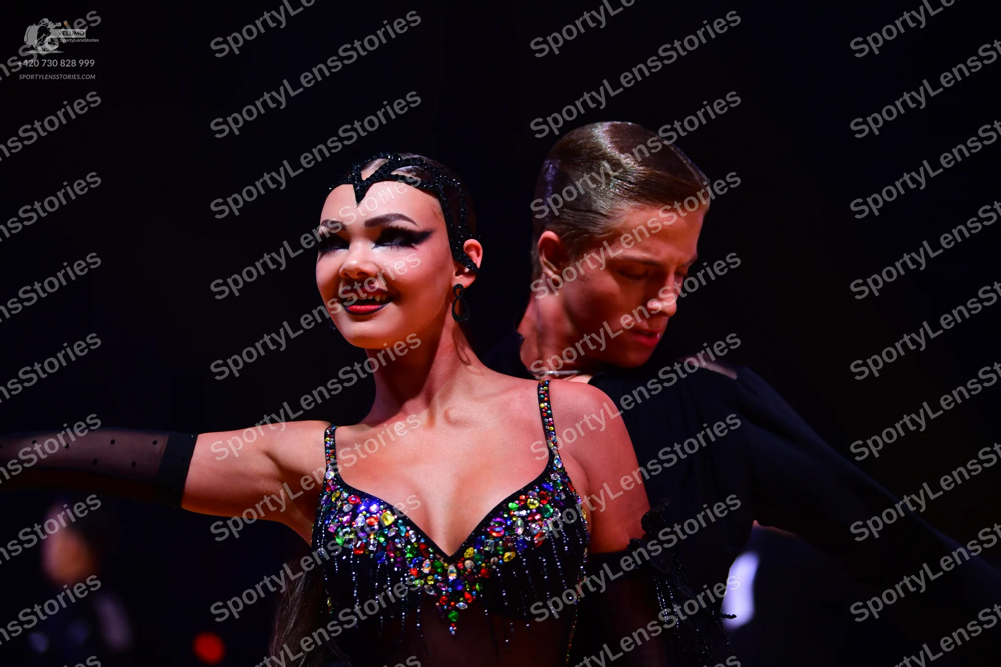 Dancesport competitor: Female dancer: black Latin dance costume with multi-colored sequins and rhinesto