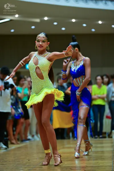 Dancesport competitor: Female dancer 1: pale yellow/lime green latin dress with cutouts, sequins, and y