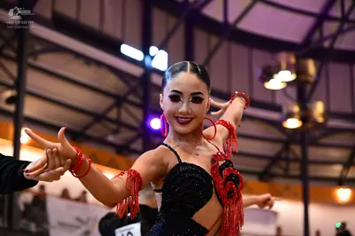 Dancesport competitor #10: Female dancer: black latin dress with red sequins and red fringe, and red hoop e