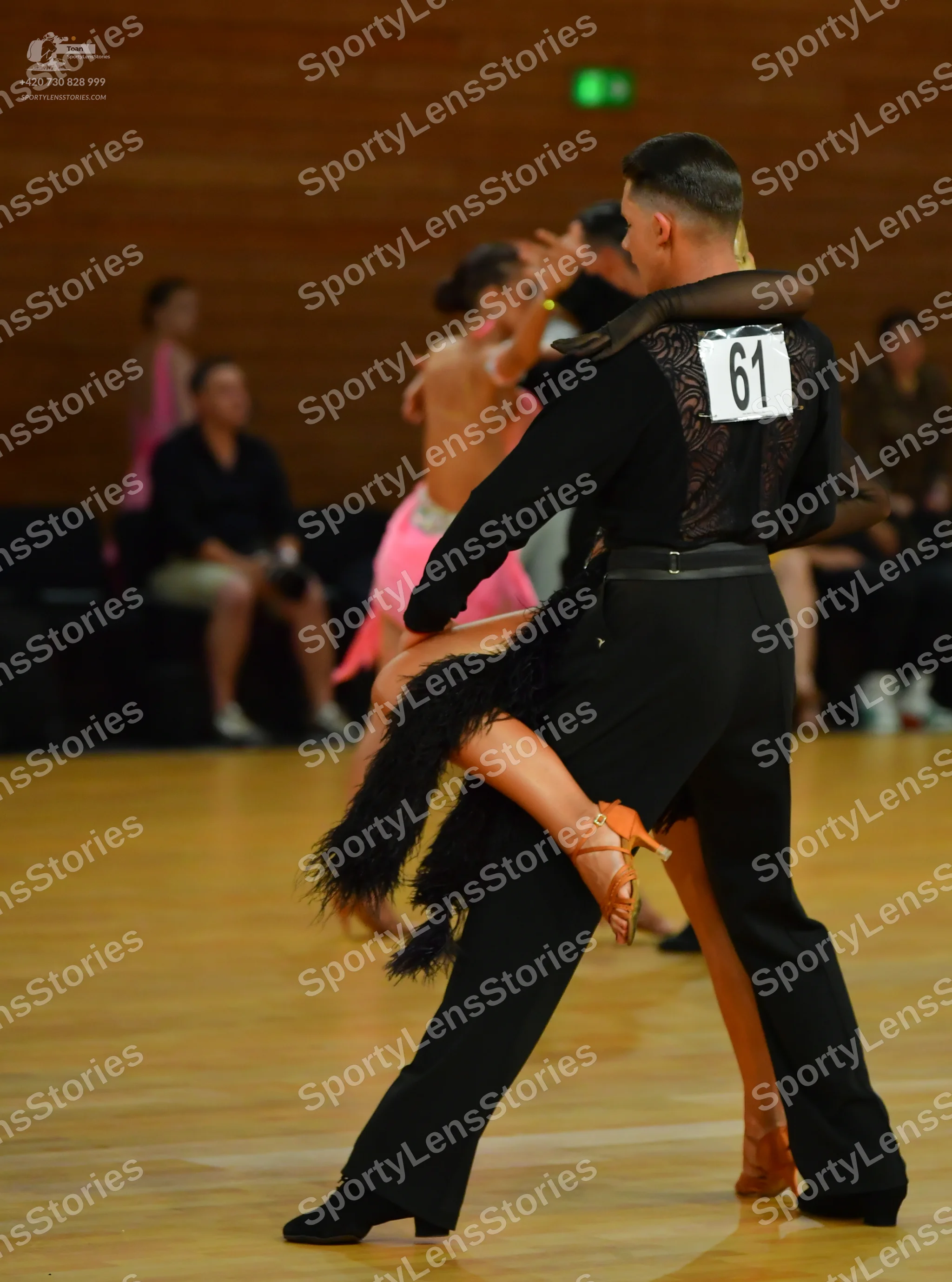 Dancesport competitor #61: Okay, here's a breakdown of the dancers' costumes in the photo, based on your re