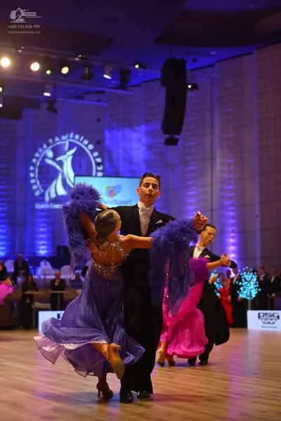Dancesport competitor: Female dancer 1: purple latin dress with a sparkly, beaded bodice and flowing sk