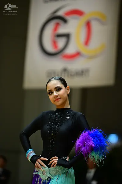 Dancesport competitor: Female dancer: black long-sleeved Latin-style costume with black sequin embellis