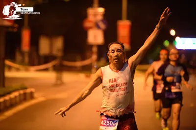 Marathon runner #42505: Runner 1: white tank top with red text, dark shorts