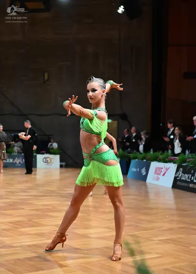 Dancesport competitor: Female dancer: lime green latin dress with sequins, cut-outs, and fringe, and ma
