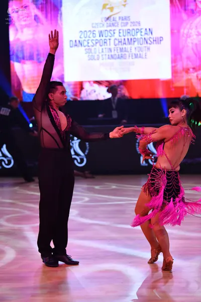 Dancesport competitor: Male dancer: black long-sleeved shirt with sheer mesh panels and black trousers