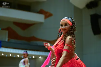 Dancesport competitor: Female dancer: red Latin dress with sequins and a matching headband