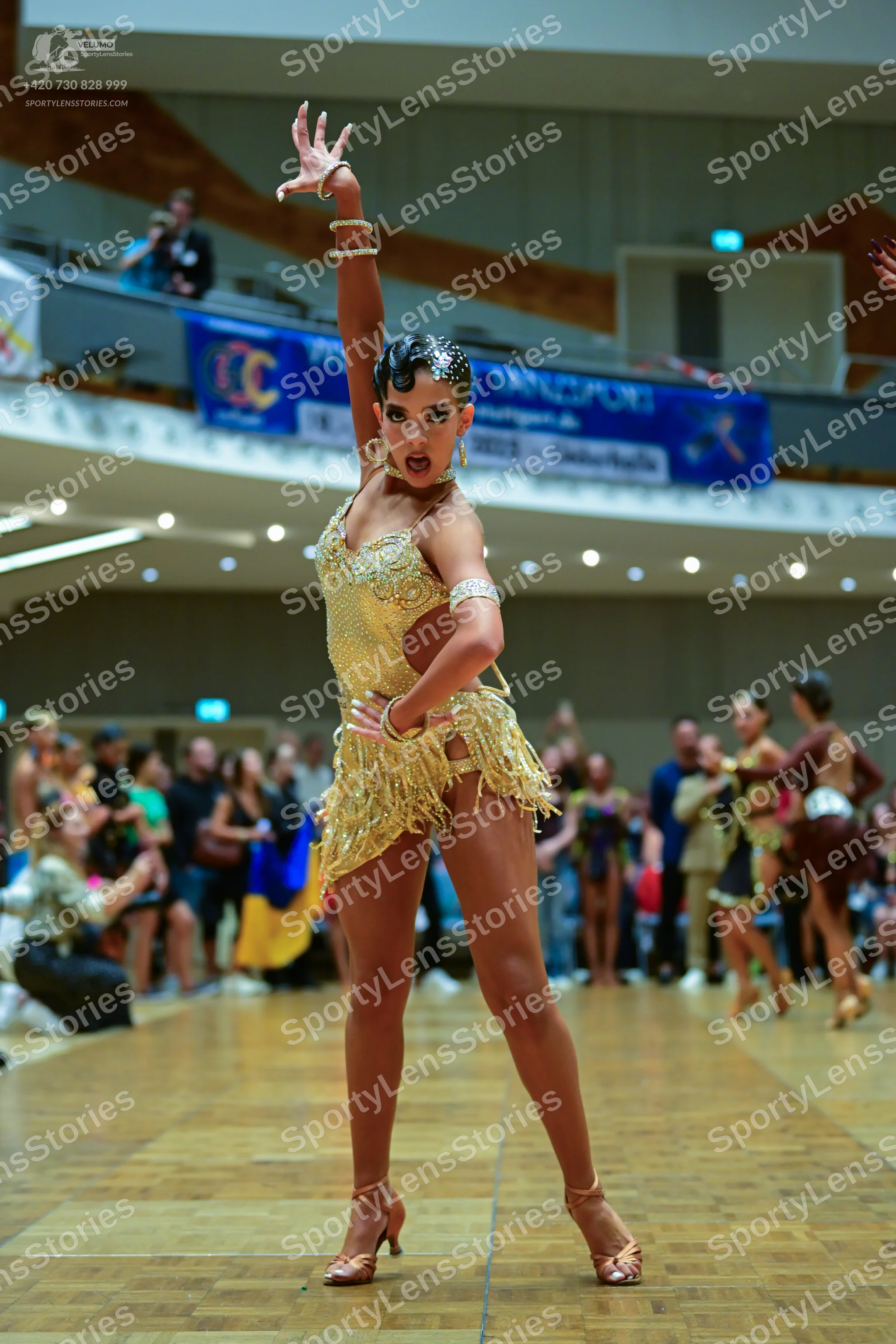 Dancesport competitor: Main female dancer: gold Latin dance costume with heavy sequin and crystal embel