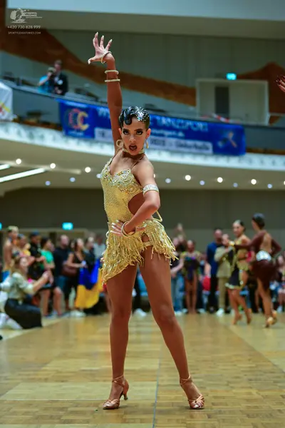 Dancesport competitor: Main female dancer: gold Latin dance costume with heavy sequin and crystal embel
