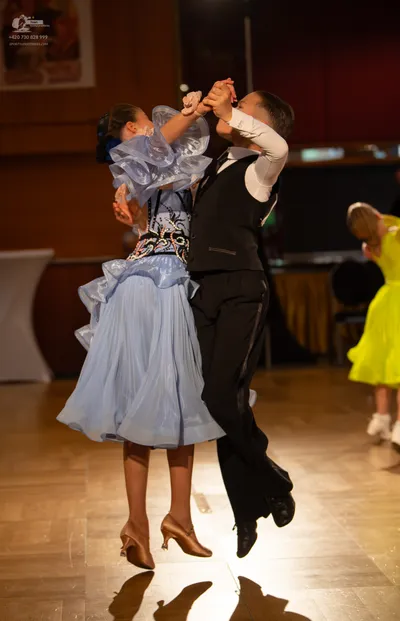 Dancesport competitor: Female dancer: light blue ballgown with voluminous, ruffled skirt and a decorate