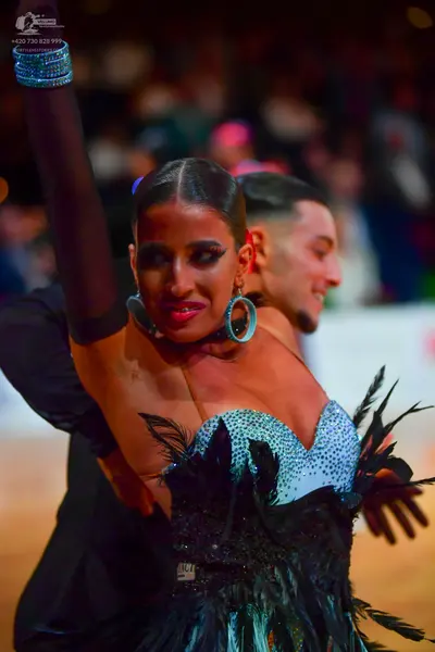 Dancesport competitor #147: Female dancer: light blue sequined strapless bodice with black feather accents, 