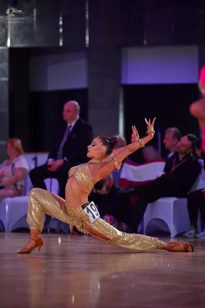 Dancesport competitor #19: Female dancer: gold metallic Latin costume consisting of a sequined crop top and
