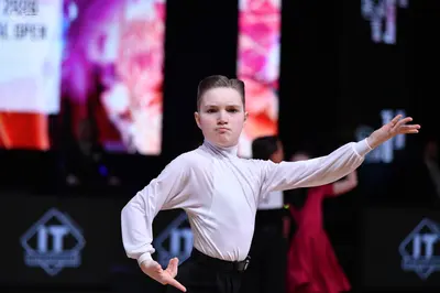 Dancesport competitor: Male dancer: white long-sleeved high-neck shirt and black trousers with a black 