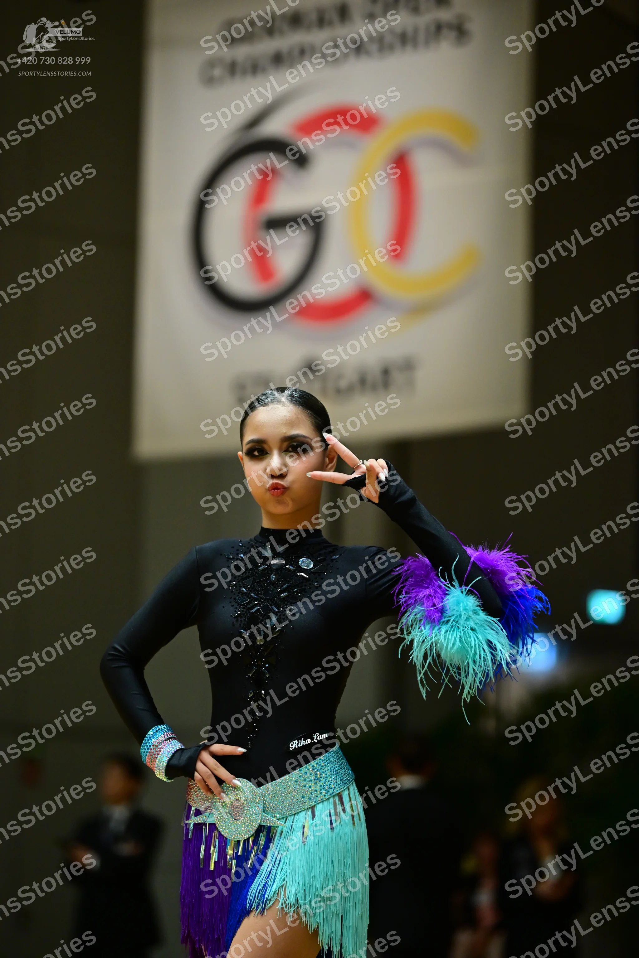 Dancesport competitor: Female dancer: black long-sleeved Latin dress with a sequined bodice and a multi
