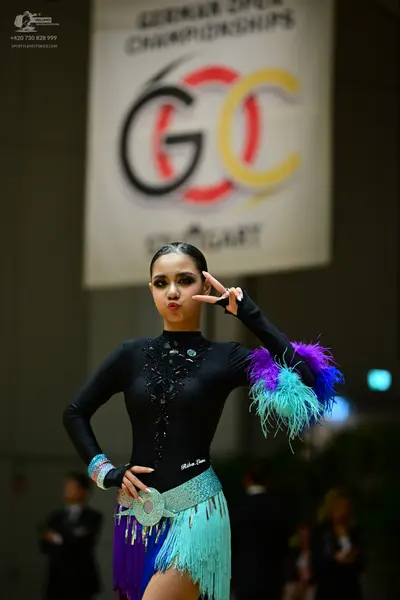 Dancesport competitor: Female dancer: black long-sleeved Latin dress with a sequined bodice and a multi