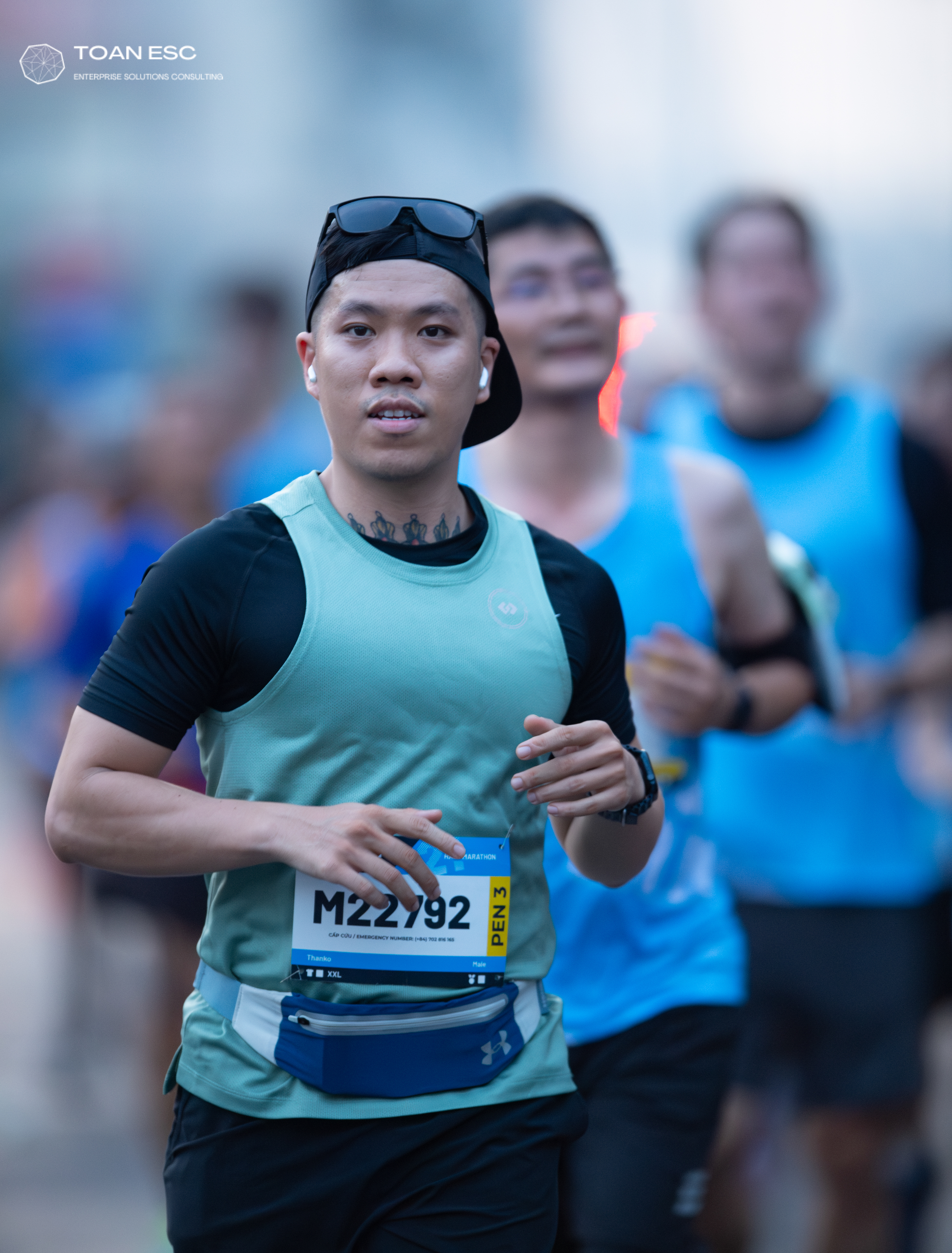Marathon runner #M22792: Runner 1: mint green tank top, black short-sleeved shirt, black shorts, blue wai