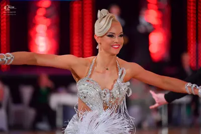 Dancesport competitor: Female dancer: white Latin dance costume with heavy silver sequin and crystal em