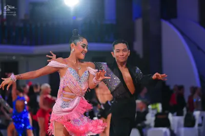 Dancesport competitor: Female dancer: pink/lavender Latin dress with sequins, cutouts, and fringe, acce