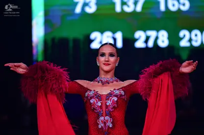 Dancesport competitor: Female dancer: red Latin dress with silver/white sequined/embellished bodice and