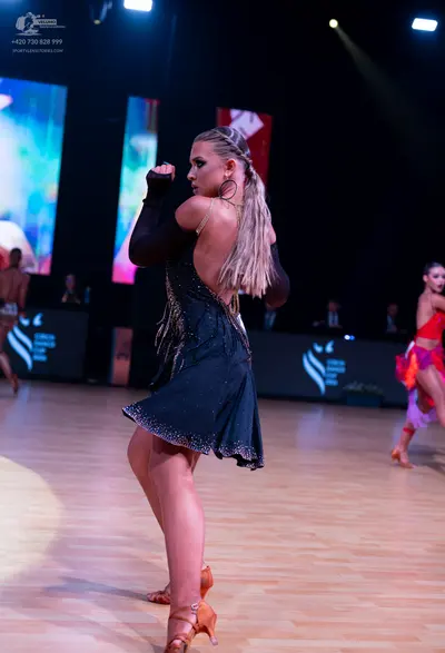 Dancesport competitor: Main female dancer: dark green Latin dress with long sleeves, backless design, a