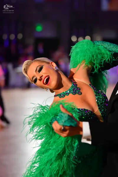 Dancesport competitor: Female dancer: Emerald green Latin dance dress featuring heavy sequin embellishm