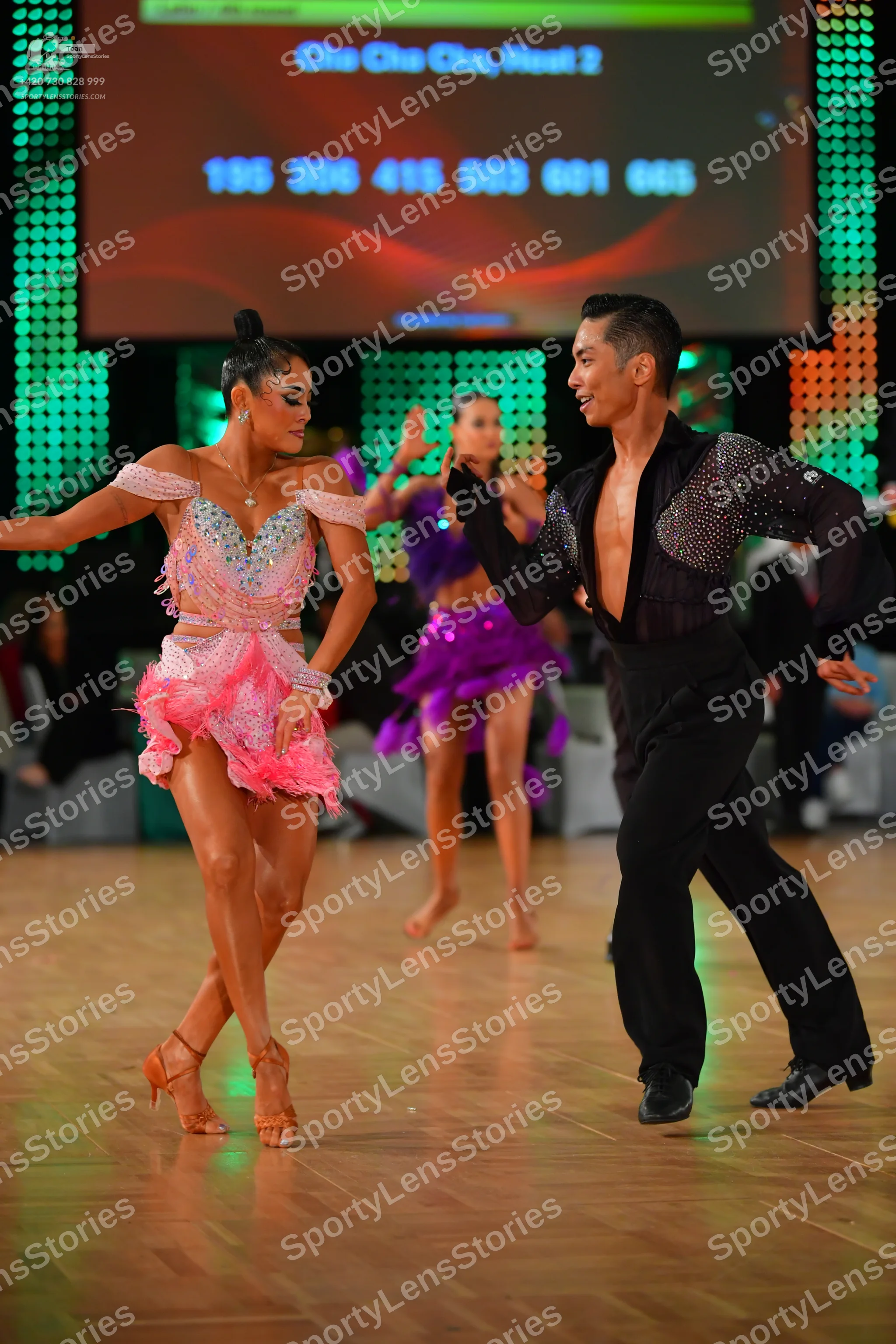 Dancesport competitor: Female dancer: pink Latin dance dress with a sequined/beaded bodice and a ruffle