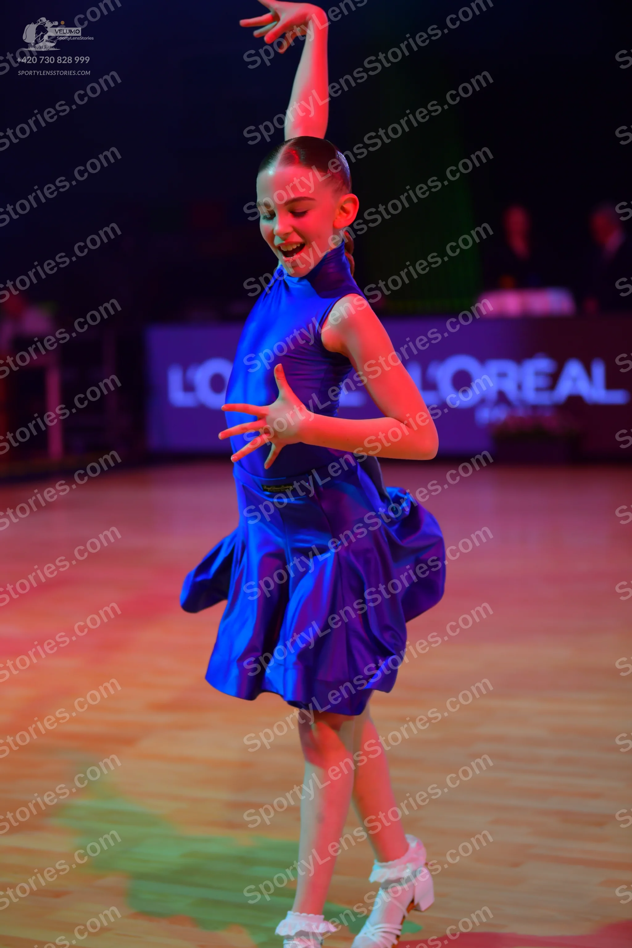 Dancesport competitor: Female dancer: royal blue dress with a high neckline and a flared skirt, made of