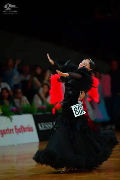 Dancesport competitor: Female dancer: black ballgown with voluminous ruffled layers