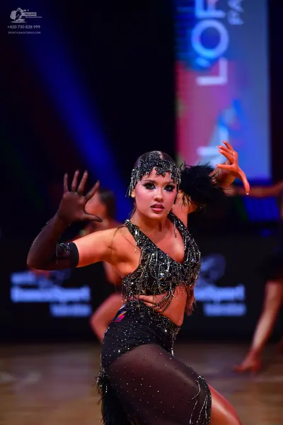 Dancesport competitor: Female dancer: black Latin dance costume with heavy sequin and crystal embellish