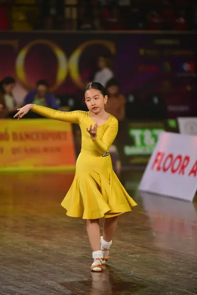 Dancesport competitor: Female dancer: yellow long-sleeved dress with a flared skirt