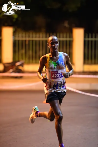 Marathon runner #42222: Runner 1: colorful patterned tank top, black shorts, white running shoes, purple