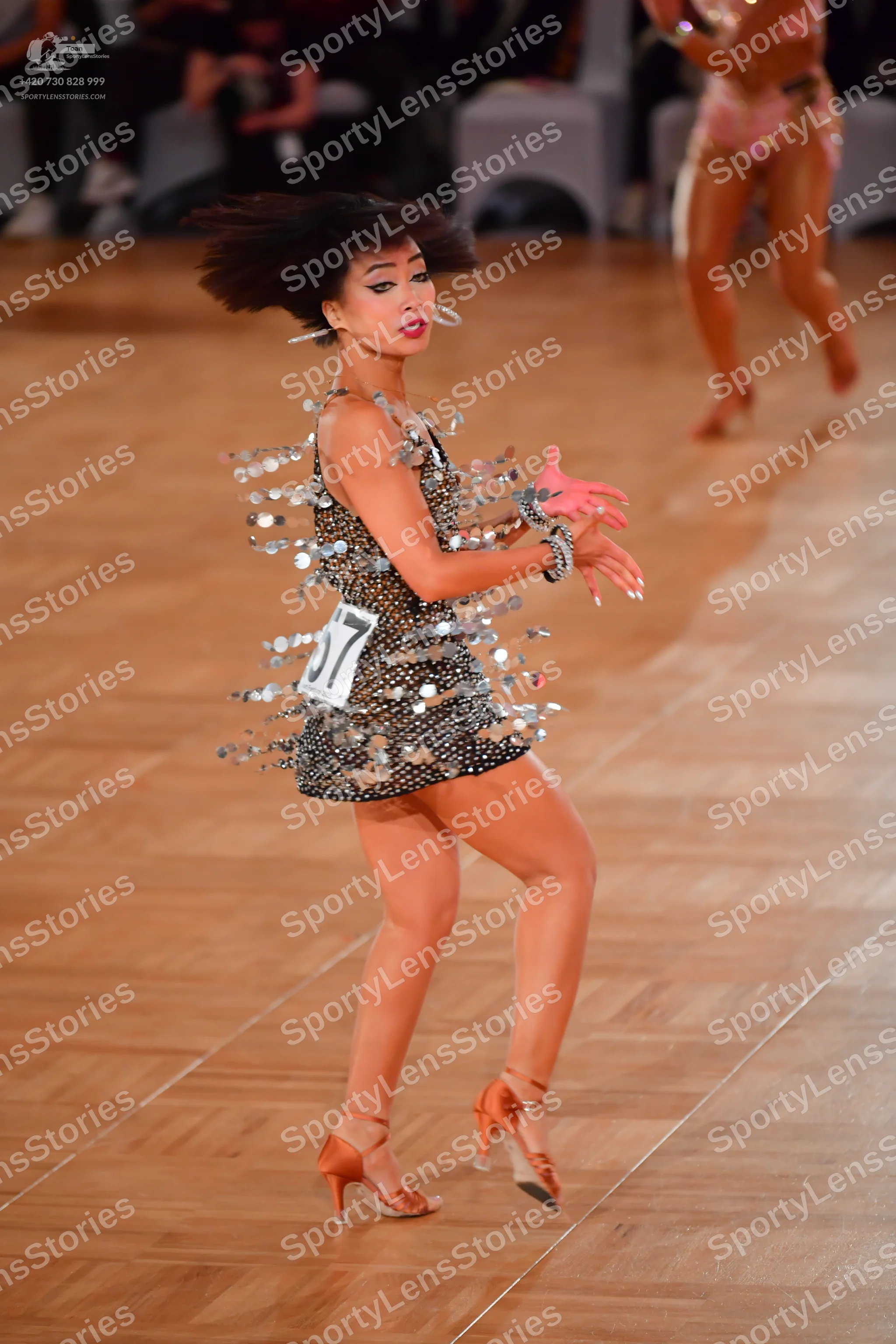 Dancesport competitor #17: Female dancer in foreground: short black Latin dress covered in large silver pai