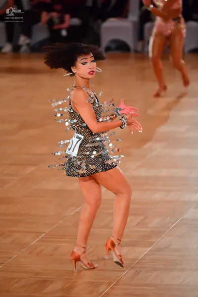 Dancesport competitor #17: Female dancer in foreground: short black Latin dress covered in large silver pai