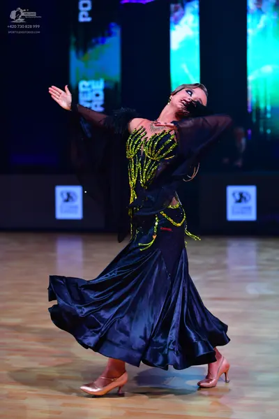 Dancesport competitor: Female dancer: Black ballroom dress with a large, flowing black skirt, a bodice 