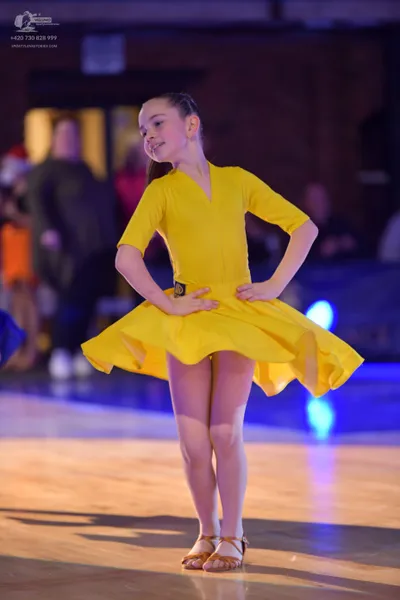 Dancesport competitor: ** Yellow, short, fitted, and ruffled Latin dress