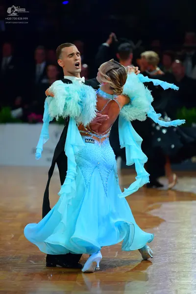 Dancesport competitor: Male dancer: black tuxedo with a white shirt and white bow tie