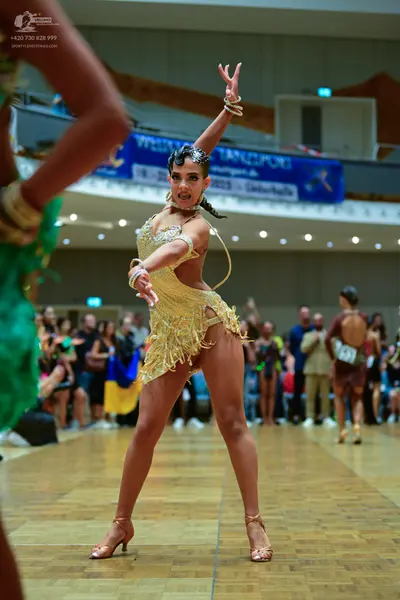 Dancesport competitor #18: Female dancer: gold sequin latin dress with fringe and gold bangles