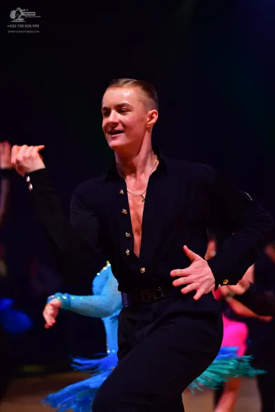 Dancesport competitor: Male dancer: black long-sleeved shirt with metallic buttons and black trousers w