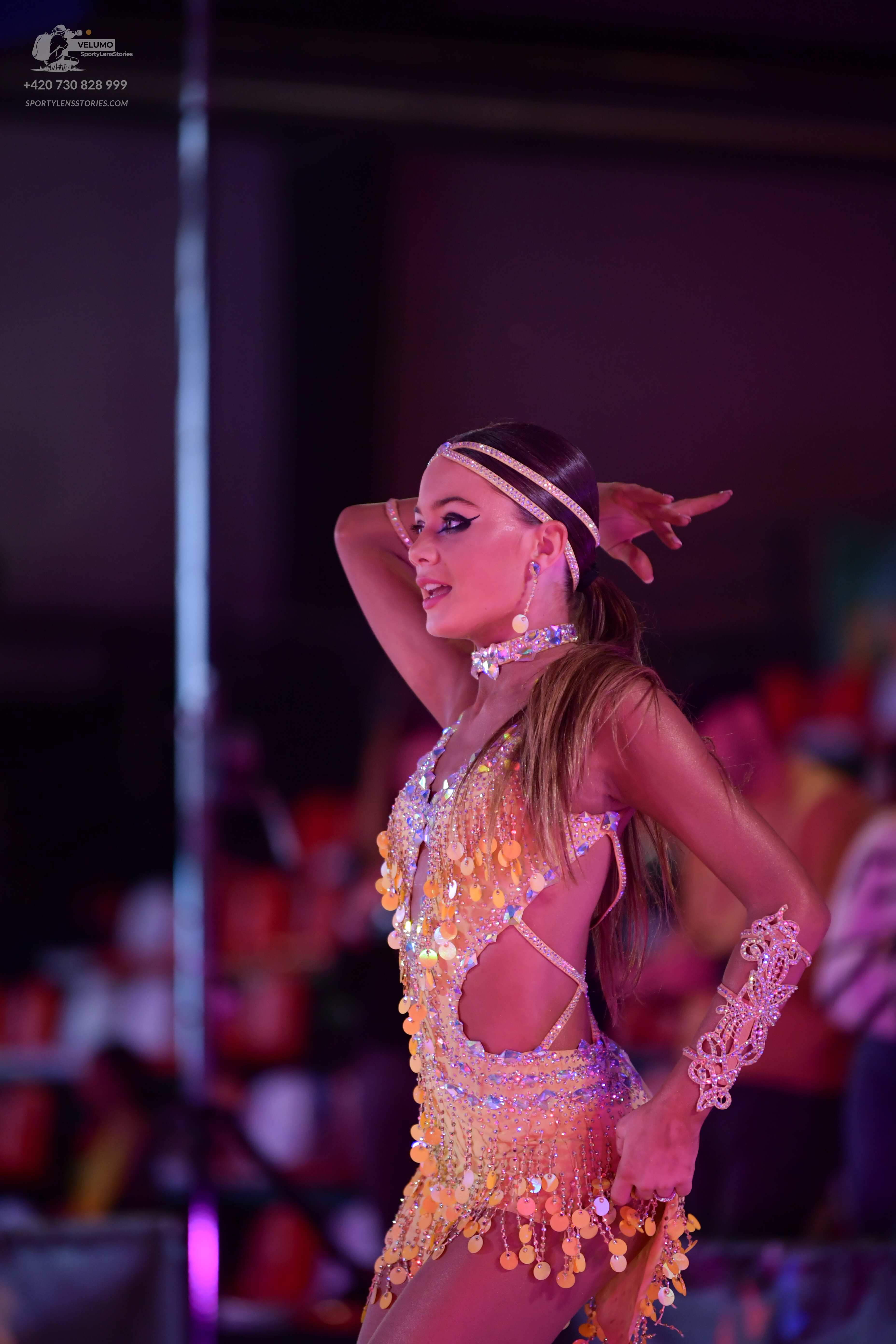 Dancesport competitor: Female dancer: gold/yellow Latin dance dress with sequins, large coin-like discs