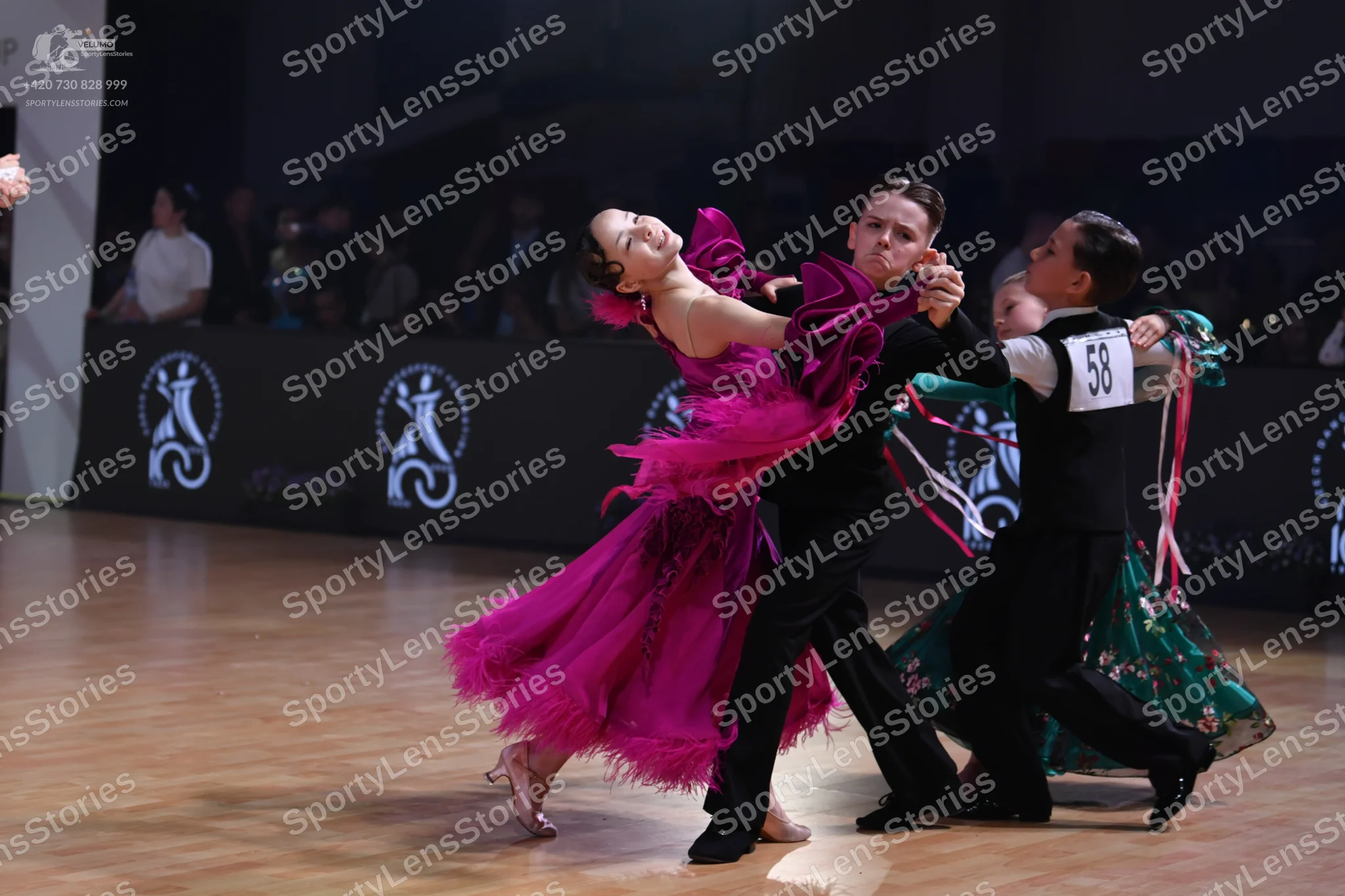 Dancesport competitor: Female dancer 1: magenta ballroom dress with voluminous ruffles