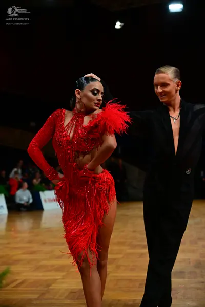 Dancesport competitor: Female dancer: red latin dress with sequins and long fringe, long sleeves