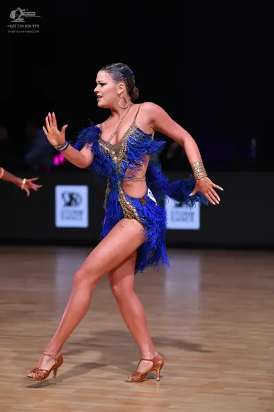 Dancesport competitor: Female dancer: blue Latin dance costume with blue fringe and gold sequins